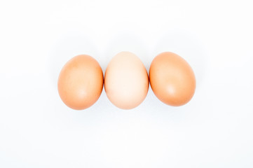 Three eggs in a row isolated on white blank background