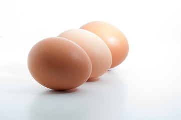 Three eggs in a row isolated on white blank background