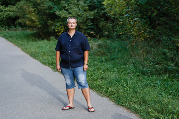 fat guy standing on a track in the woods