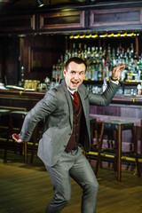 Cheerful businessman dancing in a pub at corporate party