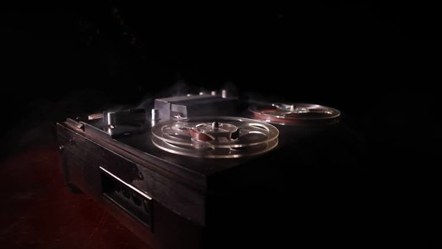 Old vintage reel to reel player and recorder on dark toned foggy background. Analog Stereo Open Reel Tape Deck Recorder Player with Reels. Selective focus