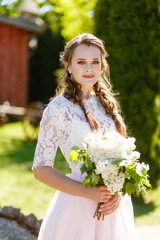 Bridesmaid in a pink dress holding flowers in her hands