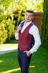 Fototapeta premium portrait of a stylish groom in the garden