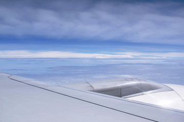 Fototapeta na wymiar plane wing and cloud floating on sky through window frame