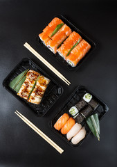 Various kinds of sushi served on black background