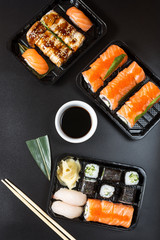 Various kinds of sushi served on black background