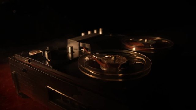 Old vintage reel to reel player and recorder on dark toned foggy background. Analog Stereo Open Reel Tape Deck Recorder Player with Reels. Selective focus