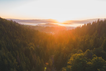 aerial view of sunset over mountains with forest and river