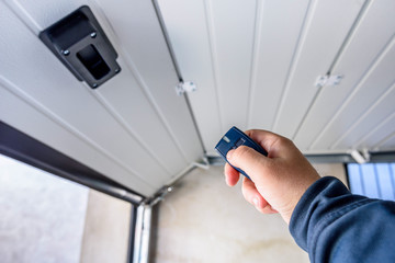 Garage door PVC. Hand use remote controller for closing and opening garage door