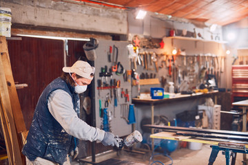 Male carpenter working on old wood in a retro vintage workshop.