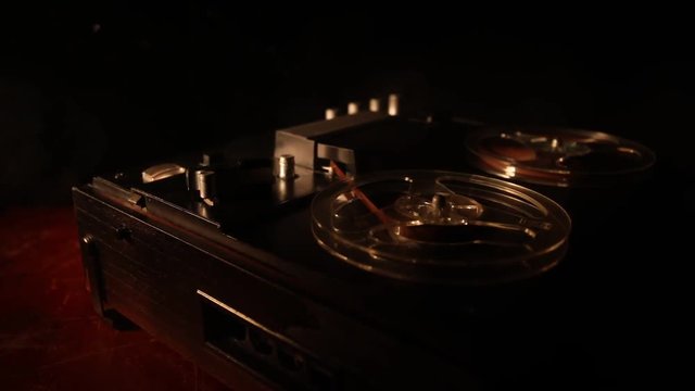Old vintage reel to reel player and recorder on dark toned foggy background. Analog Stereo Open Reel Tape Deck Recorder Player with Reels. Selective focus