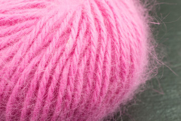 ball of pink angora wool against black background