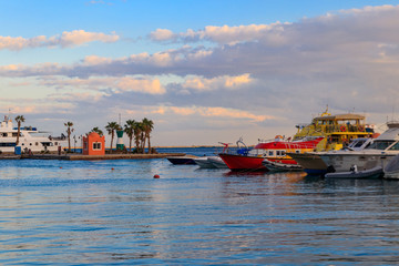Obraz premium White yachts in the sea harbor of Hurghada, Egypt. Port with tourist boats on the Red Sea