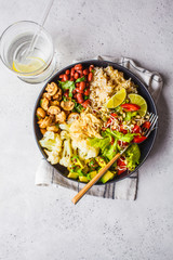 Vegetarian lunch. Brown rice with mushrooms, beans, salad and hummus in black plate, clean eatind.