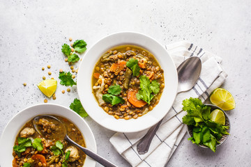 Lentil soup with vegetables in a white plate, white background, top view. Plant based food, clean...