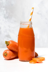 fresh carrot juice in a bottle, vertical closeup