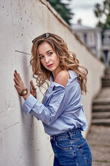 Young beautiful woman with long brown hair on a walk on a cloudy day. Close-up.