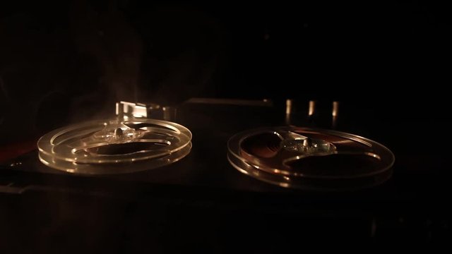 Old vintage reel to reel player and recorder on dark toned foggy background. Analog Stereo Open Reel Tape Deck Recorder Player with Reels. Selective focus