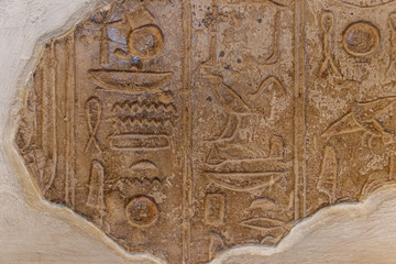 Ancient egyptian hieroglyphs carved on the stone wall