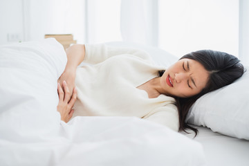 Obraz na płótnie Canvas Asian woman stomachache, feel pain for period concept