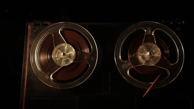 Old vintage reel to reel player and recorder on dark toned foggy background. Analog Stereo Open Reel Tape Deck Recorder Player with Reels. Selective focus