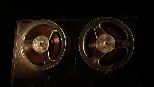 Old vintage reel to reel player and recorder on dark toned foggy background. Analog Stereo Open Reel Tape Deck Recorder Player with Reels. Selective focus