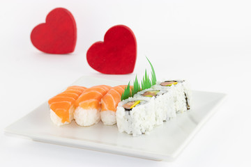 Un piatto di Sushi su sfondo bianco e cuore rosso