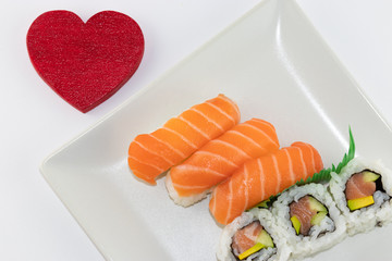 Un piatto di Sushi su sfondo bianco e cuore rosso