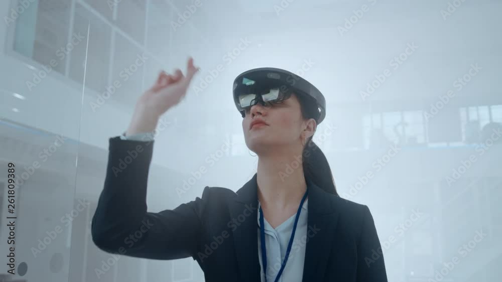 Poster female engineer using augmented reality headset. and moving virtual pieces in the air. in innovation