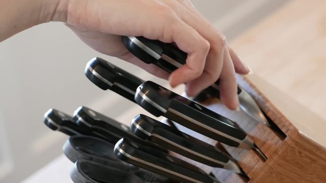 Lockoff of hand removing a large knife from a knife block.
