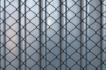 Background, texture of steel fence with rusty mesh.