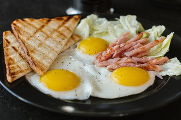 fried  soft-boiled eggs with ham sprinkled with greens and spices with toast and tea, Classic English breakfast