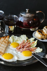 fried  soft-boiled eggs with ham sprinkled with greens and spices with toast and tea, Classic English breakfast