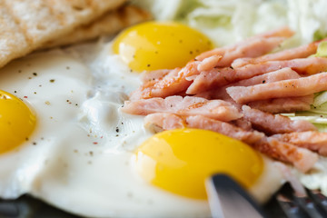 fried  soft-boiled eggs with ham sprinkled with greens and spices with toast and tea, Classic English breakfast