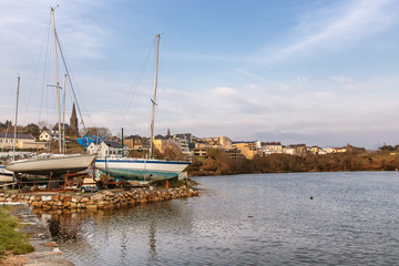 Boats in Clifden bay pier with village in background