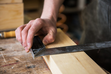 The worker makes measurements of a wooden board