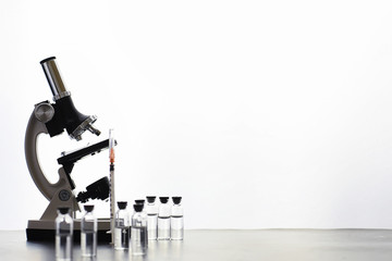 Research laboratory. Test tubes and microscope on the table on a white background.