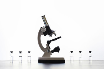 Research laboratory. Test tubes and microscope on the table on a white background.