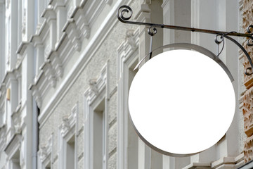 Mock up. Blank round shape signboard on the wall of classical architecture building