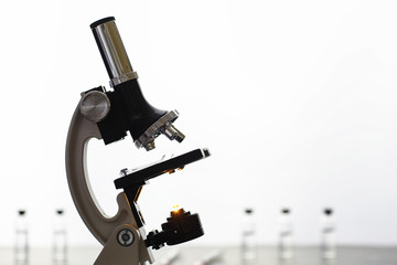 Research laboratory. Test tubes and microscope on the table on a white background.
