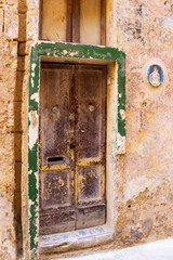Fototapeta na wymiar Beautiful old, weathered, locked door of an abandoned building at Mdina, Malta