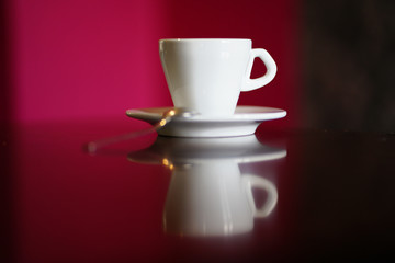  isolated white coffee cup with plate and spoon with reflection and red background
