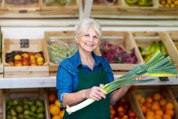 Senior woman working in small grocery store
