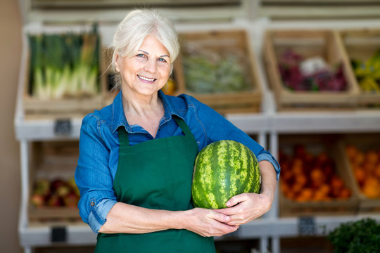 Senior woman working in small grocery store