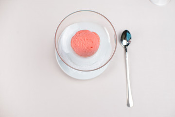 ball of strawberry ice cream in a glass beaker
