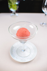 ball of strawberry ice cream in a glass beaker