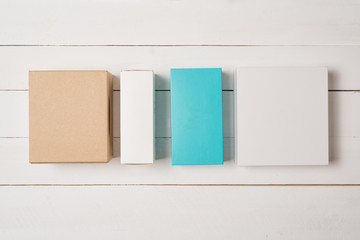 Multicolored gift boxes on a light wooden background. Flat lay