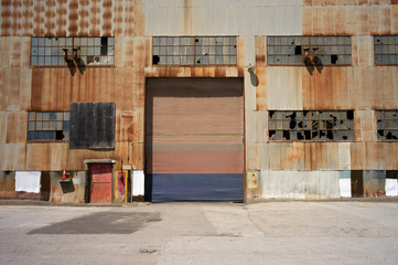 abandoned industrial building on a pier with wondows, door, rust