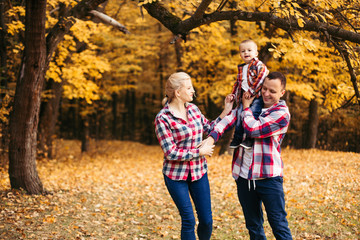 Fototapeta premium Little cute son playing with parents in forest