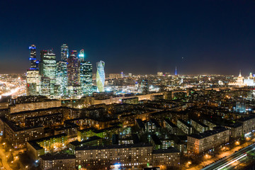 Obraz premium high-rise buildings and transport metropolis, traffic and blurry lights of cars on multi-lane highways and road junction at night in Moscow.